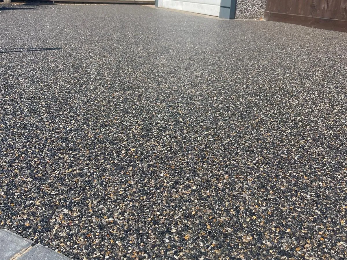 Black and gold resin bound driveway with grey block edging, laid by First4Driveways