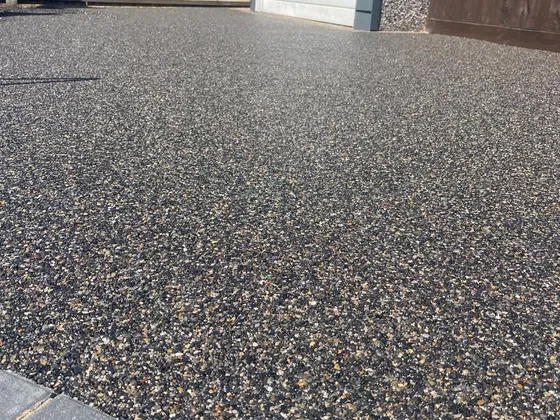 Black and gold resin bound driveway with grey block edging