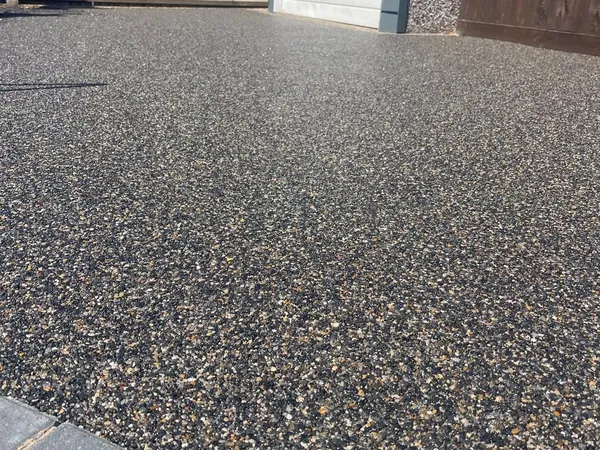Black and gold resin bound driveway with grey block edging