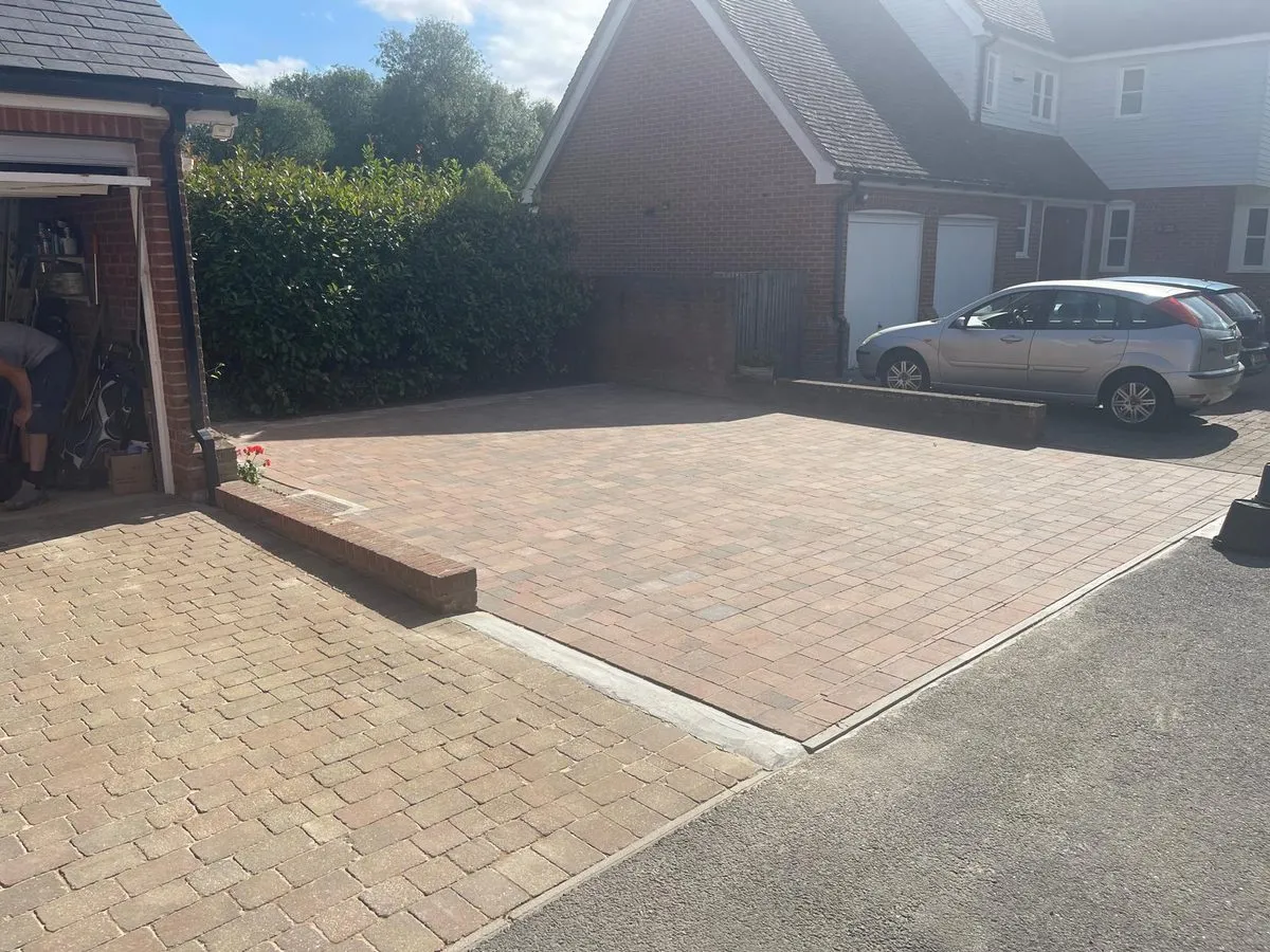 Buff and brindle herringbone block paving driveway with a soldier-course border at a red-brick detached house, laid by First4Driveways