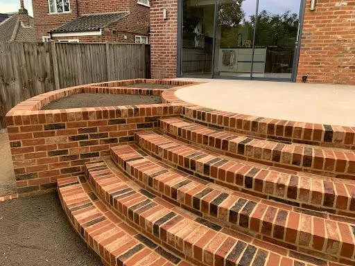 Curved red-brick steps leading up to a raised patio