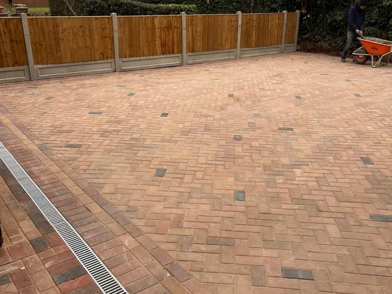 Drainage channel set into block paving at the threshold of a house