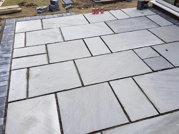 Large-format slab patio laid in a running pattern outside bifold doors