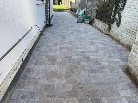 The same side of the house with new grey tumbled block paving