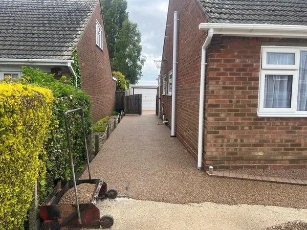 Golden resin bound side path between a bungalow and a hedge