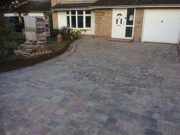 Brindle Tegula-style cobble block paving with a red border in front of a white garage door